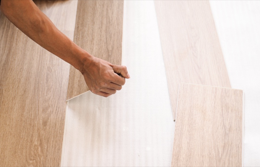 Craftsman laying new wood flooring during a property renovation